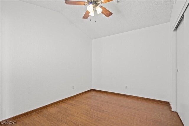 unfurnished room featuring lofted ceiling, ceiling fan, wood finished floors, and baseboards