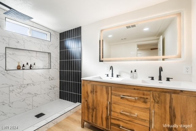 bathroom with a tile shower, vanity, and hardwood / wood-style flooring