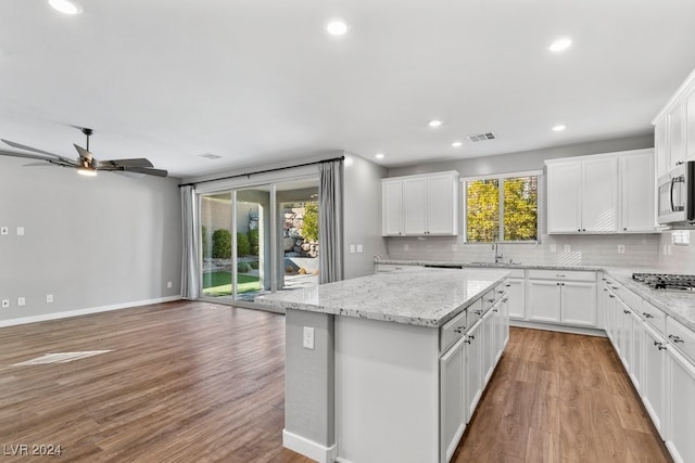 kitchen with white cabinetry, plenty of natural light, a kitchen island, and stainless steel appliances