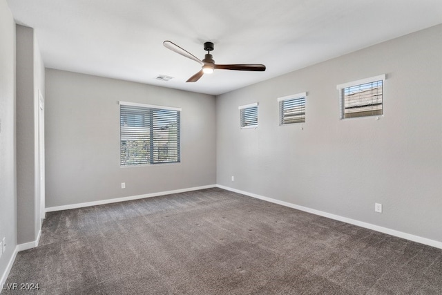 carpeted empty room featuring ceiling fan and a wealth of natural light