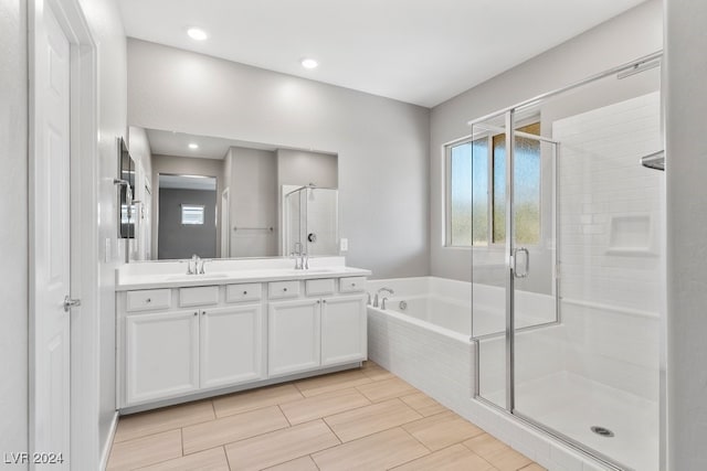 bathroom featuring shower with separate bathtub and vanity