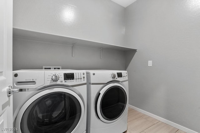 clothes washing area with light hardwood / wood-style floors and independent washer and dryer