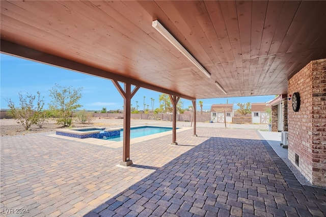 view of pool with a patio area and an in ground hot tub