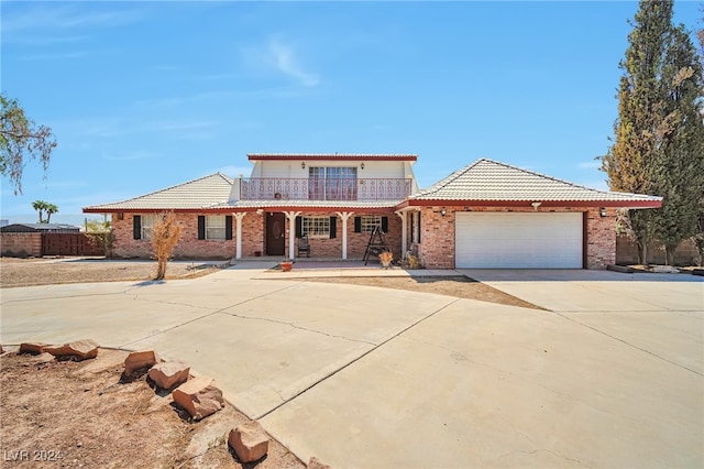 view of front of property featuring a porch, a garage, and a balcony