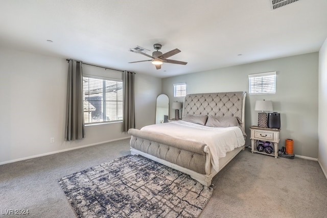 carpeted bedroom with multiple windows and ceiling fan