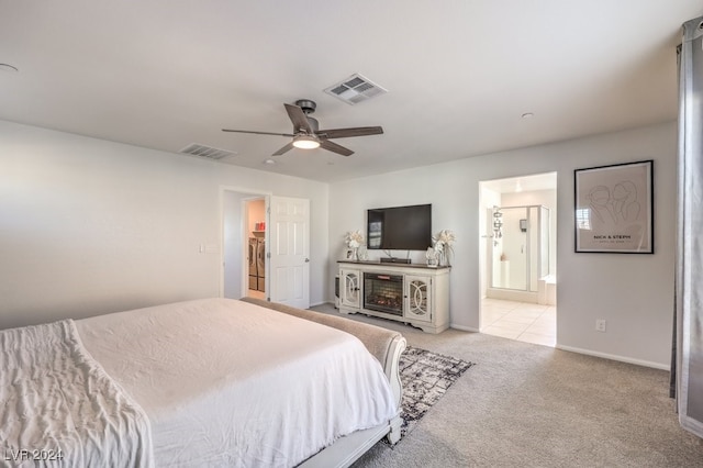 bedroom featuring ceiling fan, light colored carpet, and ensuite bathroom