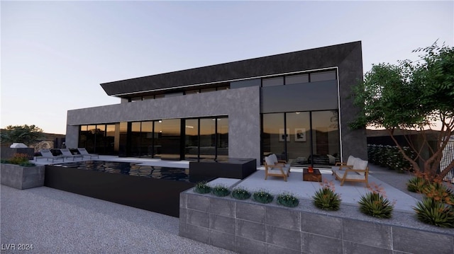 back house at dusk featuring an outdoor hangout area and a patio area