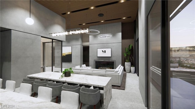 dining area featuring wood ceiling, exterior fireplace, and a high ceiling