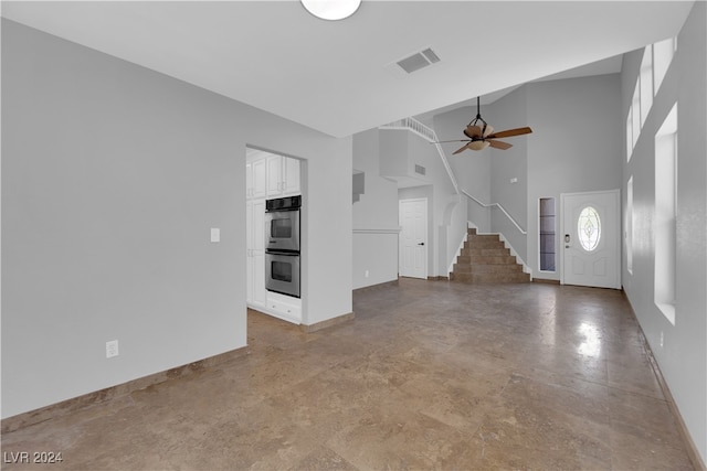 entryway featuring ceiling fan and a high ceiling