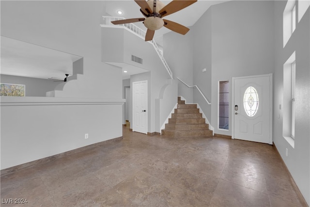 entryway with ceiling fan and a high ceiling