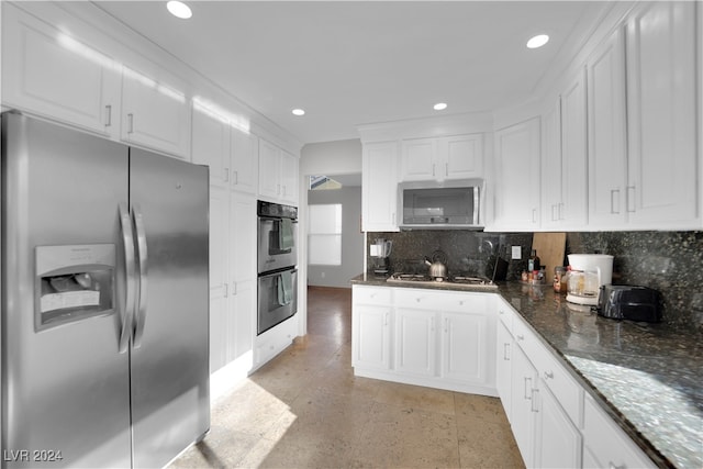 kitchen featuring white cabinets, backsplash, dark stone countertops, and stainless steel appliances