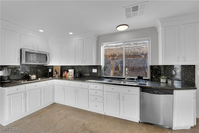 kitchen featuring white cabinets, backsplash, sink, and appliances with stainless steel finishes