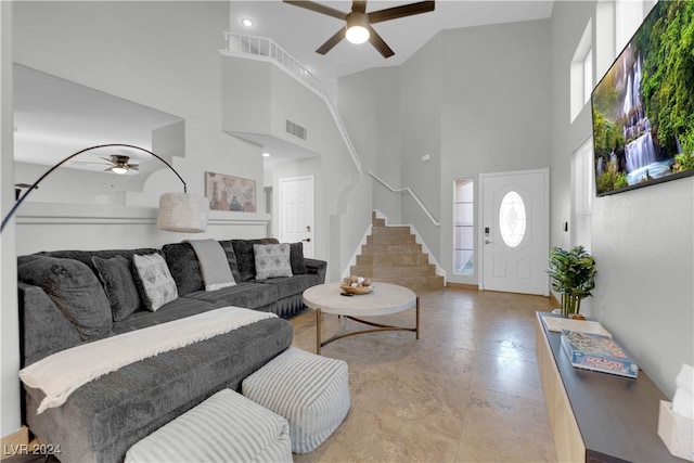 living room with ceiling fan and a high ceiling