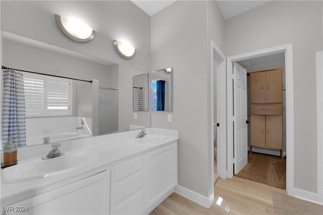 bathroom with hardwood / wood-style floors, vanity, and a tub