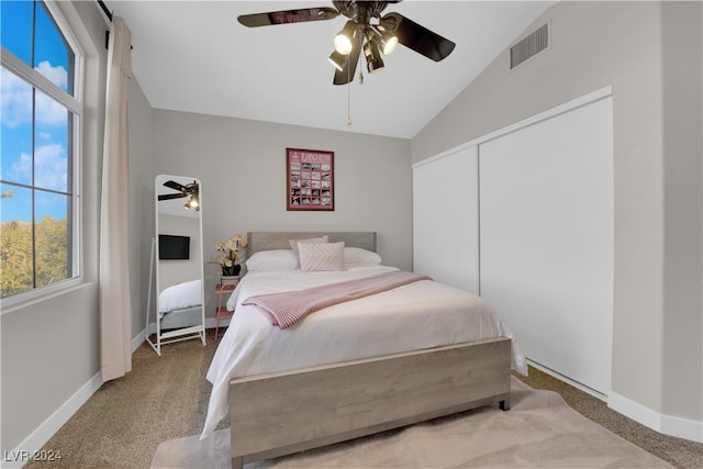 carpeted bedroom featuring ceiling fan, lofted ceiling, and a closet