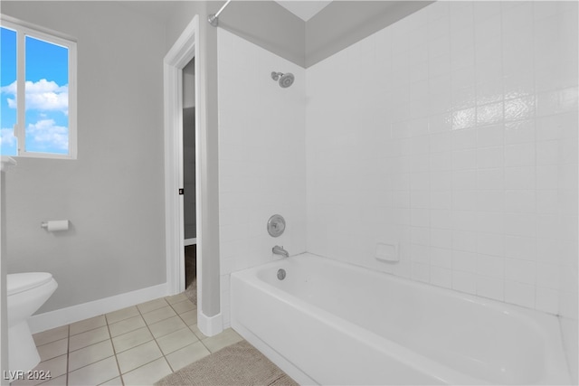 bathroom featuring tile patterned floors, toilet, and tiled shower / bath