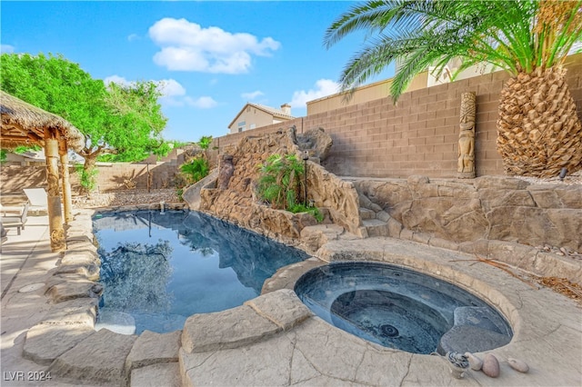 view of swimming pool with an in ground hot tub