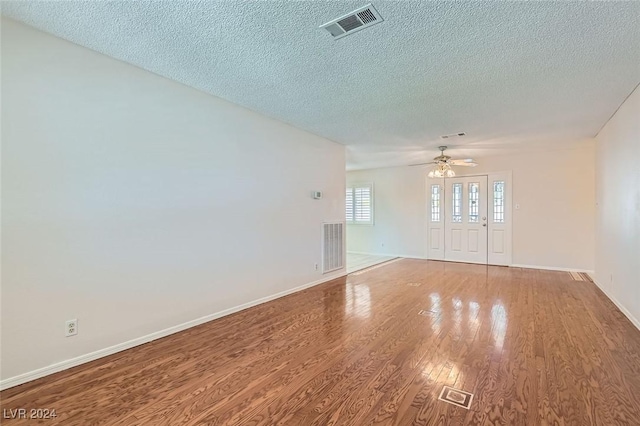 empty room featuring hardwood / wood-style floors, a textured ceiling, and ceiling fan