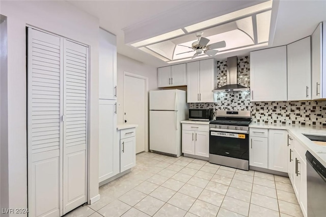 kitchen with white cabinetry, appliances with stainless steel finishes, backsplash, and wall chimney exhaust hood