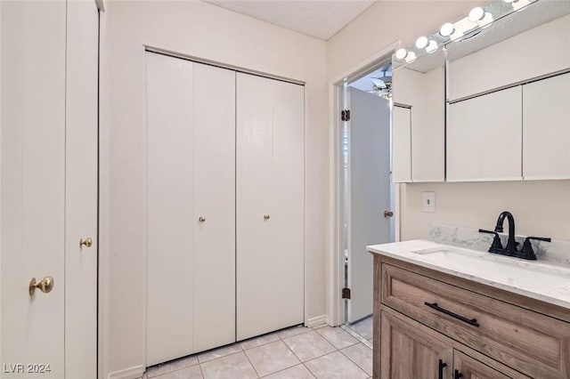 bathroom with vanity, ceiling fan, tile patterned floors, and a textured ceiling