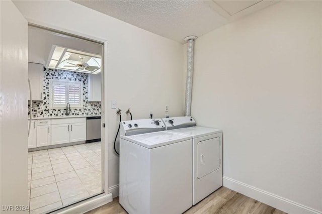 laundry area with independent washer and dryer, sink, a textured ceiling, light wood-type flooring, and ceiling fan