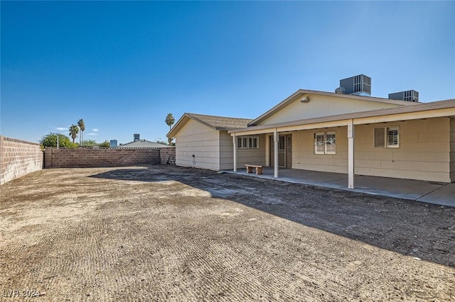 rear view of property with cooling unit and a patio area