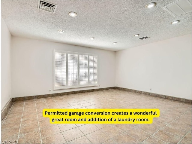 tiled empty room with a textured ceiling