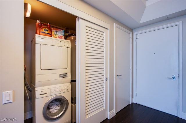 laundry room with stacked washer / dryer and dark wood-type flooring