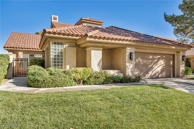 mediterranean / spanish home featuring a front yard and a garage