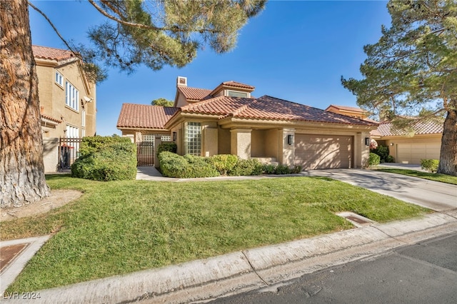 mediterranean / spanish-style home featuring a garage and a front lawn