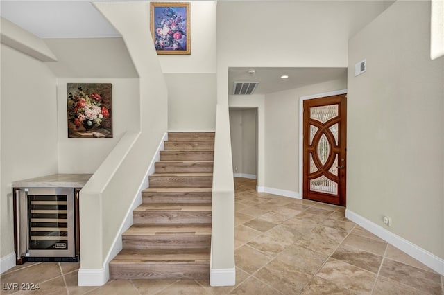 foyer featuring beverage cooler and indoor bar