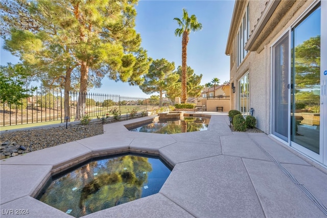 view of pool with a patio area and an in ground hot tub