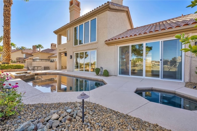 exterior space featuring an in ground hot tub and a patio