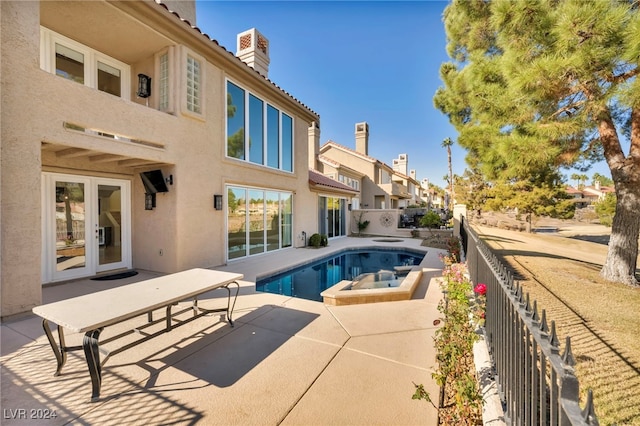 view of pool featuring a patio area, an in ground hot tub, and french doors