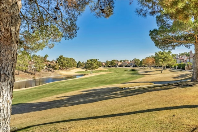 view of property's community with a water view and a lawn