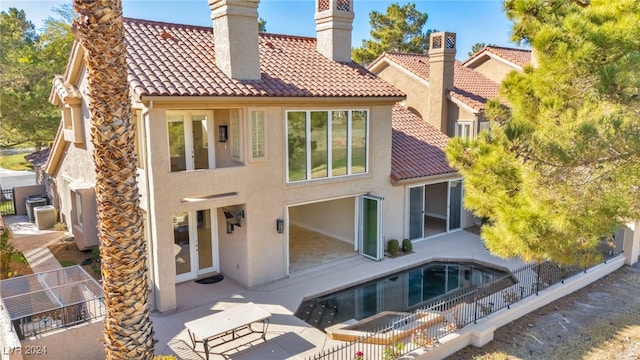 back of property with a fenced in pool and a patio