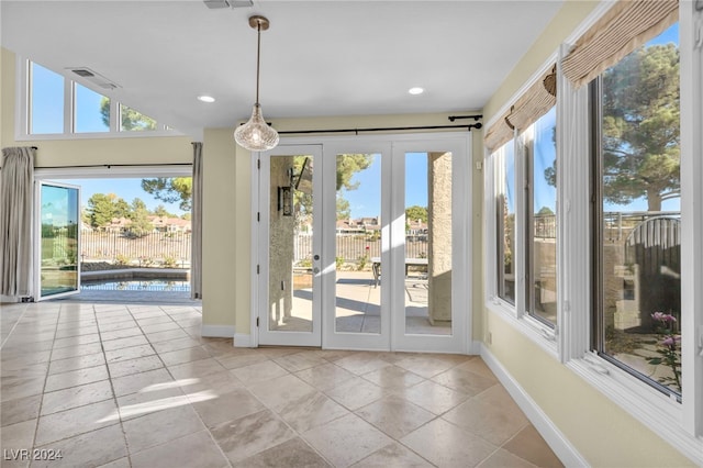 doorway with plenty of natural light, light tile patterned floors, and french doors