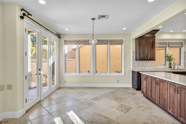 kitchen with decorative light fixtures, backsplash, and french doors