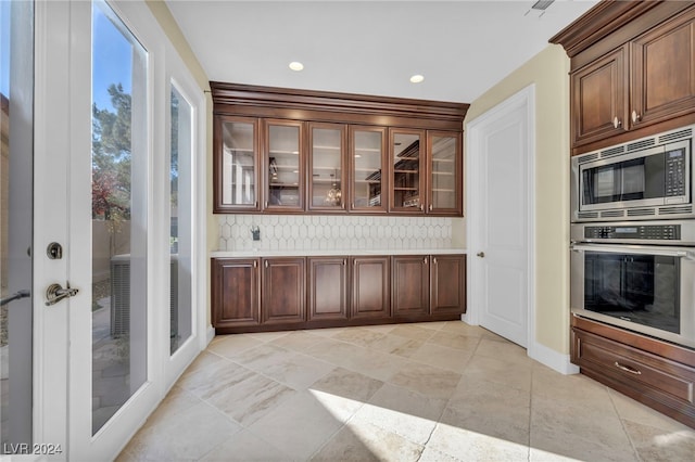 bar with backsplash, dark brown cabinetry, and stainless steel appliances