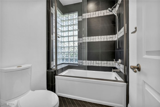 bathroom featuring shower / bath combination with glass door and toilet