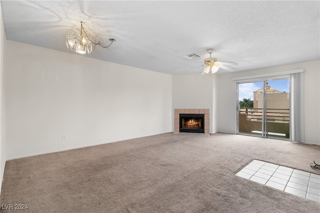 unfurnished living room featuring a textured ceiling, ceiling fan with notable chandelier, carpet flooring, and a fireplace