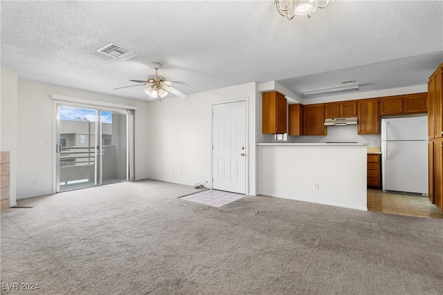 unfurnished living room with light carpet, ceiling fan, and a textured ceiling