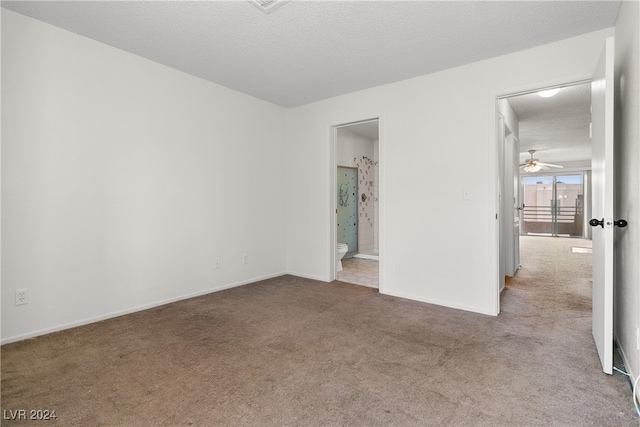 spare room featuring carpet flooring, a textured ceiling, and ceiling fan