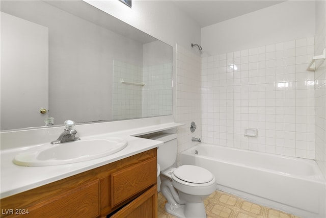 full bathroom featuring tiled shower / bath, vanity, and toilet