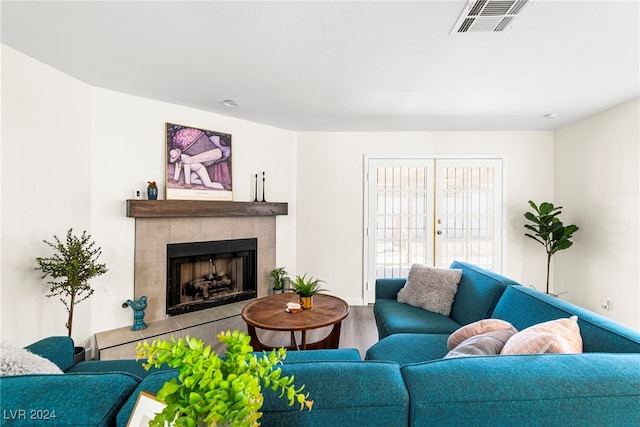 living room featuring a tile fireplace and hardwood / wood-style flooring