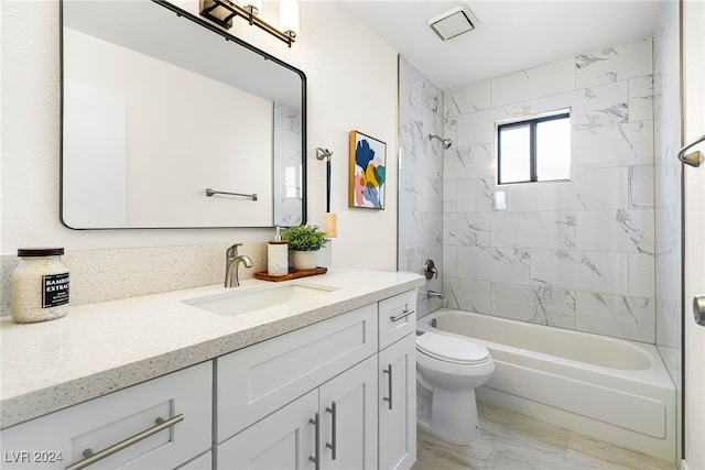 full bathroom featuring vanity, tiled shower / bath combo, and toilet