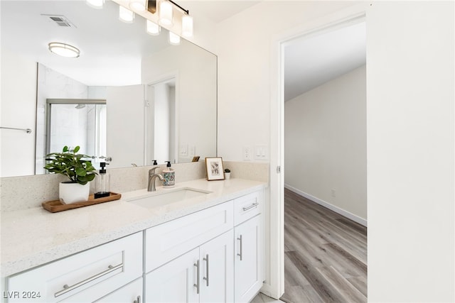 bathroom featuring hardwood / wood-style floors, vanity, and a shower with door