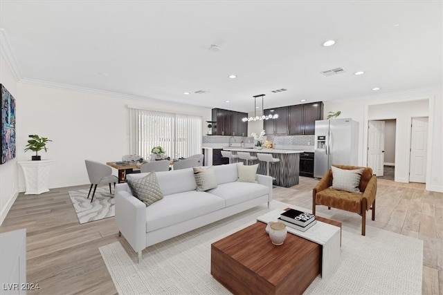 living room with light wood-type flooring and crown molding