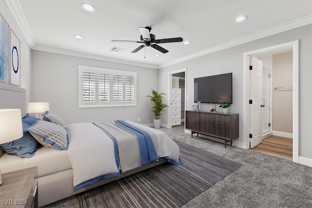 bedroom with carpet flooring, a spacious closet, ceiling fan, and ornamental molding