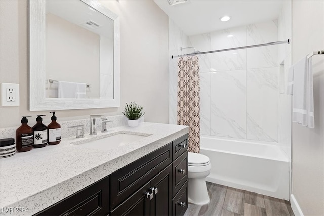 full bathroom featuring vanity, hardwood / wood-style flooring, toilet, and shower / bathtub combination with curtain